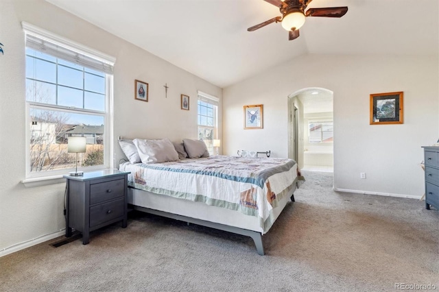 carpeted bedroom featuring lofted ceiling, ceiling fan, and ensuite bath