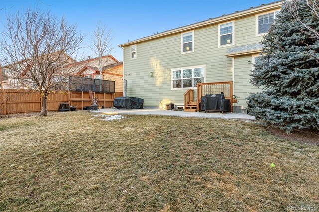 back of house with a patio and a lawn