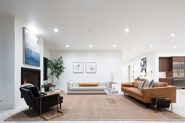 living area with baseboards, a lit fireplace, and recessed lighting