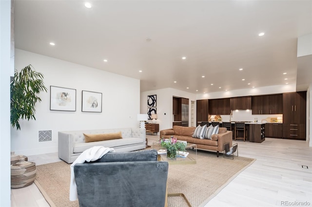 living area featuring light wood-style flooring, visible vents, and recessed lighting