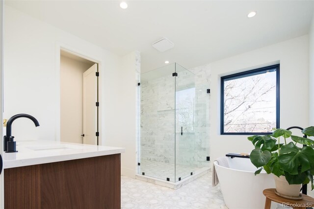 bathroom with recessed lighting, a freestanding bath, a shower stall, and vanity