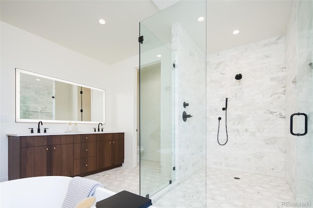 full bathroom featuring double vanity, a stall shower, a sink, and recessed lighting