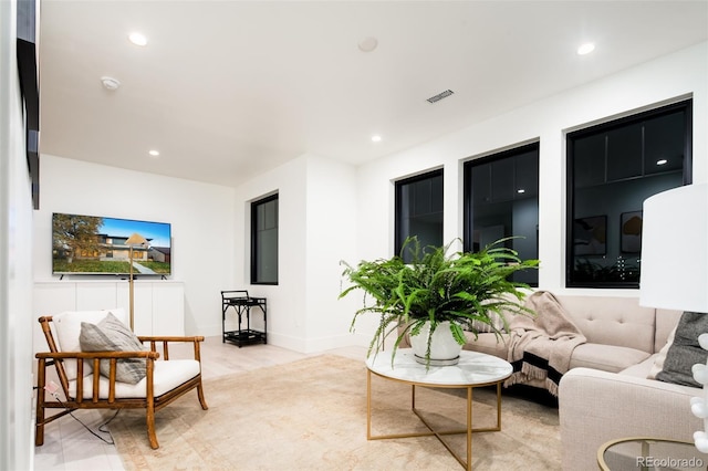 living room with baseboards, light wood-type flooring, visible vents, and recessed lighting