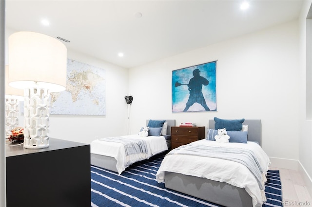 bedroom featuring baseboards, visible vents, wood finished floors, and recessed lighting