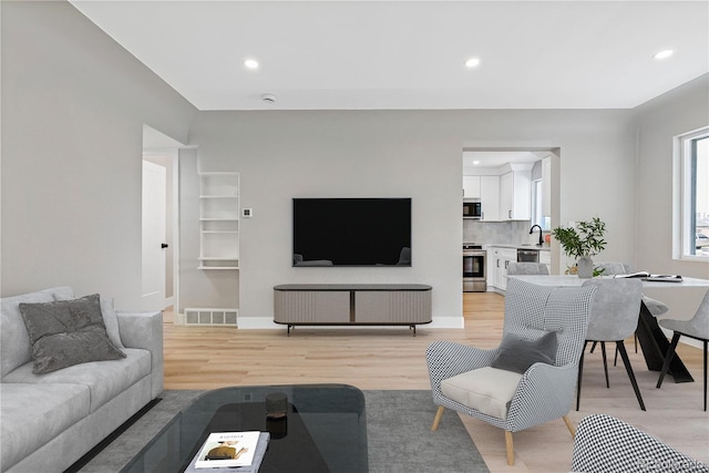 living room featuring light hardwood / wood-style flooring and sink