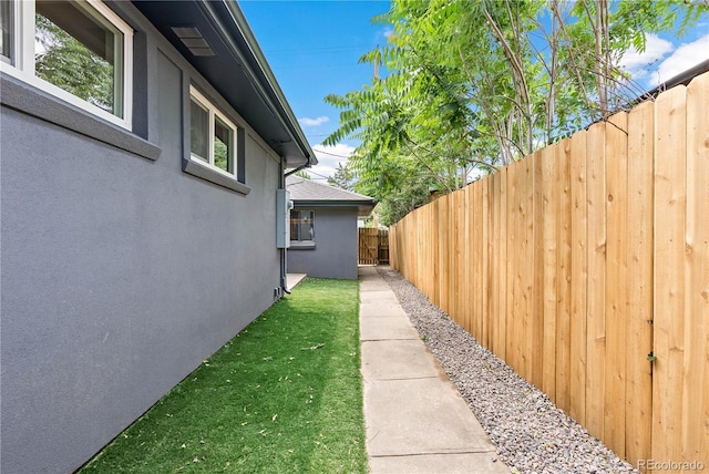 view of home's exterior featuring a yard, fence, and stucco siding