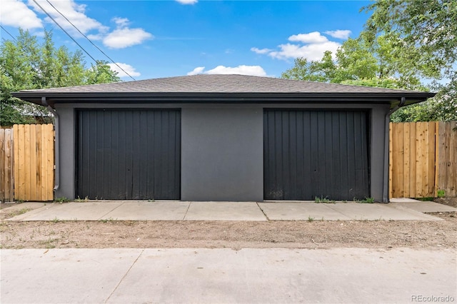 detached garage featuring fence