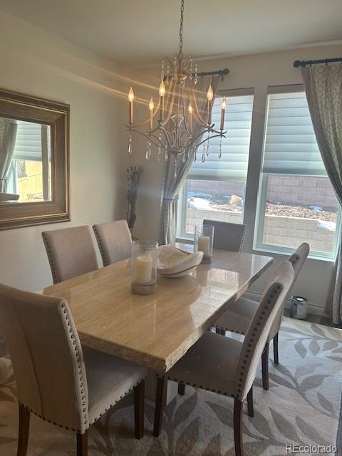 carpeted dining room featuring a chandelier