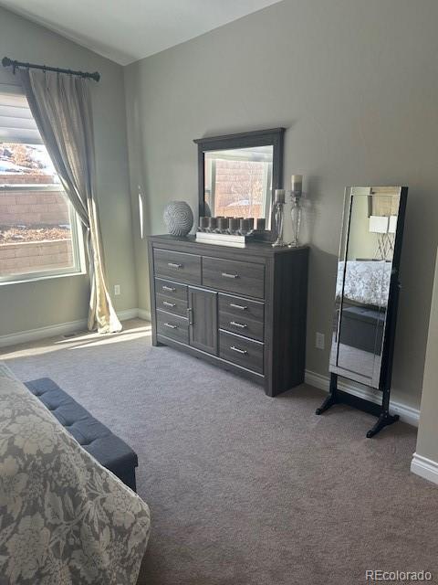 carpeted bedroom with lofted ceiling