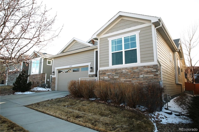 view of front of property with stone siding, an attached garage, and concrete driveway