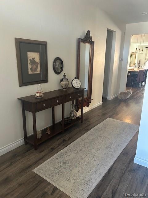 hallway featuring baseboards and dark wood-style flooring