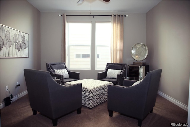 living area featuring baseboards, carpet, and ceiling fan