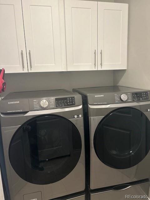 clothes washing area featuring cabinet space and independent washer and dryer