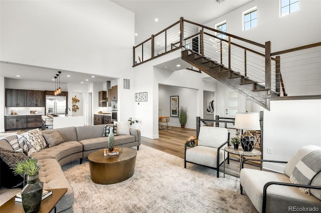 16262 W 95th Ln, Arvada, CO 80007 - living area featuring a high ceiling, light wood-style flooring, stairway, and recessed lighting