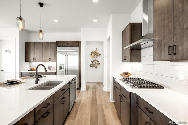 16262 W 95th Ln, Arvada, CO 80007 - kitchen with appliances with stainless steel finishes, wall chimney range hood, light countertops, dark brown cabinetry, and backsplash