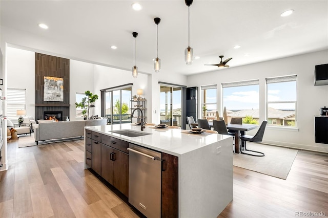 16262 W 95th Ln, Arvada, CO 80007 - kitchen with stainless steel dishwasher, open floor plan, recessed lighting, a tile fireplace, and light countertops