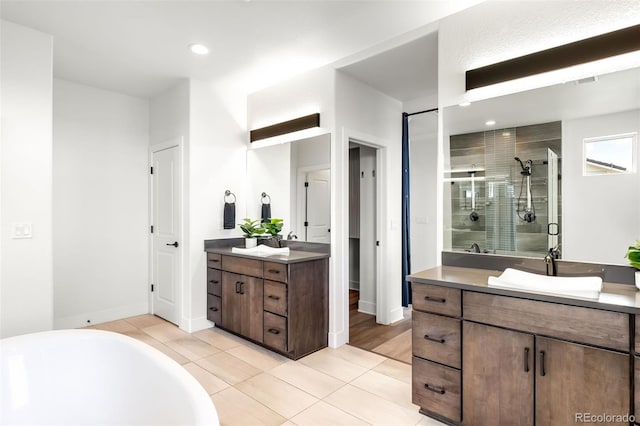 16262 W 95th Ln, Arvada, CO 80007 - bathroom featuring a stall shower, two vanities, tile patterned flooring, a soaking tub, and recessed lighting