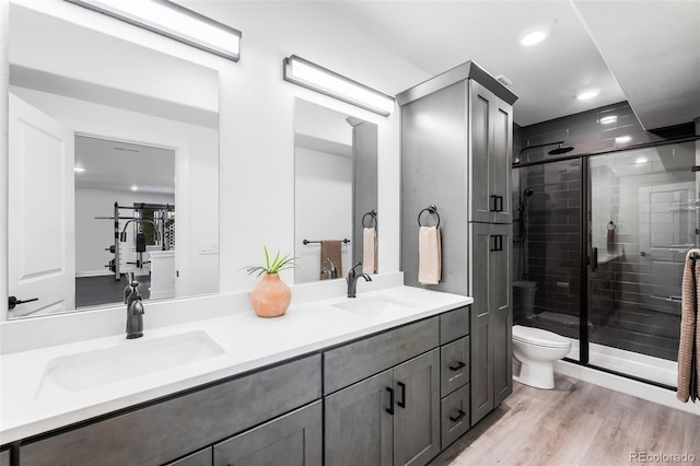 16262 W 95th Ln, Arvada, CO 80007 - bathroom with double vanity, a stall shower, recessed lighting, and wood finished floors