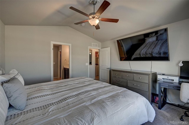 carpeted bedroom with ceiling fan, vaulted ceiling, and ensuite bath