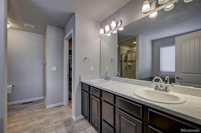 bathroom featuring vanity, hardwood / wood-style floors, and walk in shower