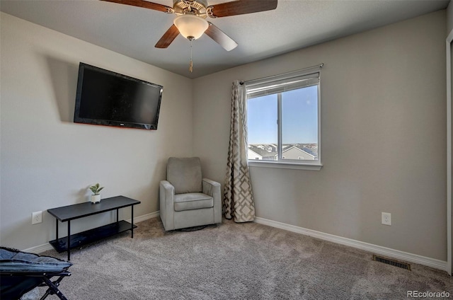 living area featuring light colored carpet and ceiling fan