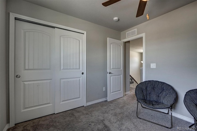 living area featuring light carpet and ceiling fan