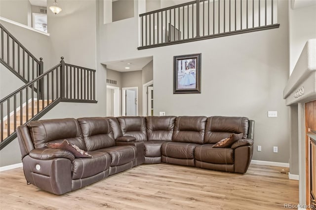 15021 Josephine St, Thornton, CO 80602 - living area featuring stairway, a high ceiling, and light wood finished floors