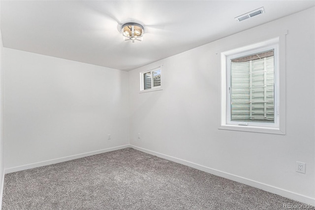 spare room with carpet floors, baseboards, and visible vents