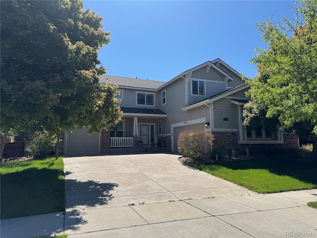 9994 Quintero St, Commerce City, CO 80022 - view of front of property with driveway, a garage, covered porch, a front lawn, and stone siding