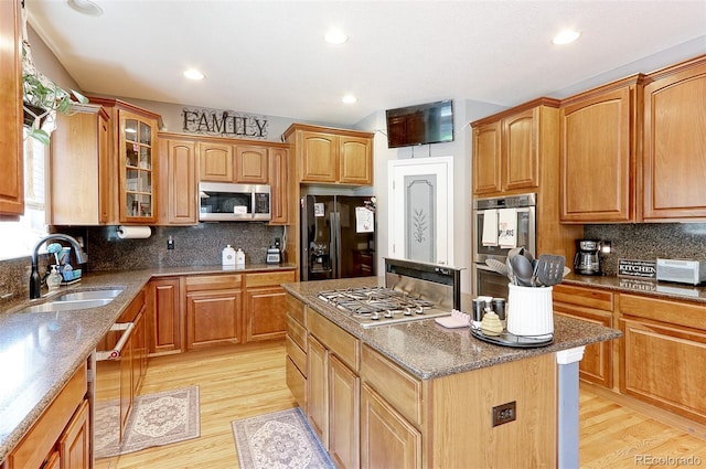 9994 Quintero St, Commerce City, CO 80022 - kitchen featuring stainless steel appliances, a kitchen island, stone countertops, a sink, and light wood-style floors