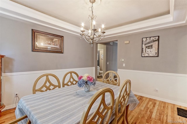 9994 Quintero St, Commerce City, CO 80022 - dining space with a chandelier, light wood-type flooring, a tray ceiling, and crown molding