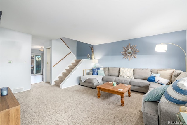 carpeted living area with visible vents and stairs