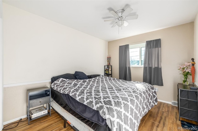 bedroom featuring ceiling fan, wood finished floors, visible vents, and baseboards