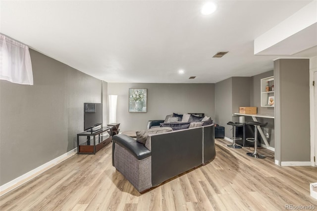 living area featuring light wood-style floors, recessed lighting, visible vents, and baseboards