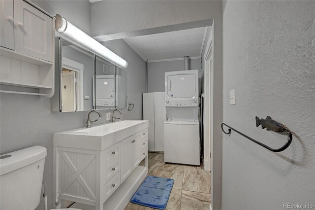 4642 Plettner Ln, Evergreen, CO 80439 - bathroom with stacked washer / drying machine, marble finish floors, a textured wall, toilet, and vanity