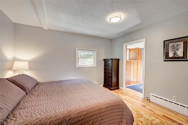 4642 Plettner Ln, Evergreen, CO 80439 - bedroom with baseboard heating, light wood finished floors, and beamed ceiling