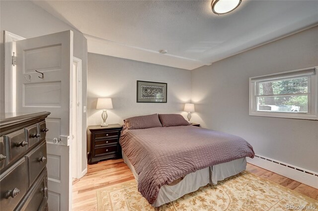 4642 Plettner Ln, Evergreen, CO 80439 - bedroom featuring light wood finished floors and a baseboard radiator