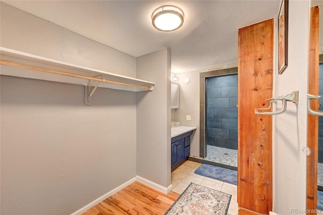 4642 Plettner Ln, Evergreen, CO 80439 - full bathroom with a stall shower, vanity, wood finished floors, and baseboards