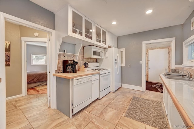 4642 Plettner Ln, Evergreen, CO 80439 - kitchen featuring white appliances, a sink, white cabinetry, light countertops, and decorative backsplash