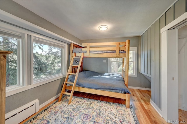 4642 Plettner Ln, Evergreen, CO 80439 - bedroom featuring a baseboard radiator, light wood-style floors, and baseboards