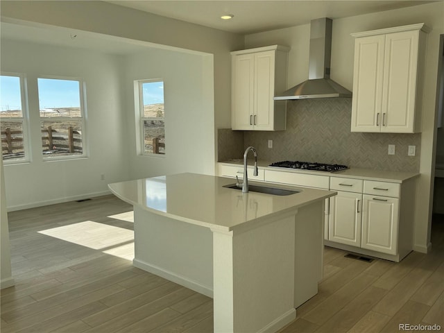 16468 W 92nd Pl, Arvada, CO 80007 - kitchen with wall chimney exhaust hood, gas cooktop, light wood-style floors, decorative backsplash, and recessed lighting