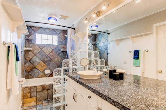 full bath with tiled shower / bath, crown molding, vanity, and a textured ceiling