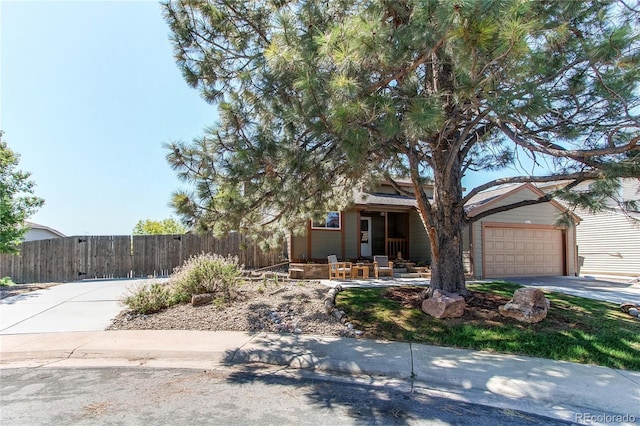 obstructed view of property with fence, a porch, and driveway