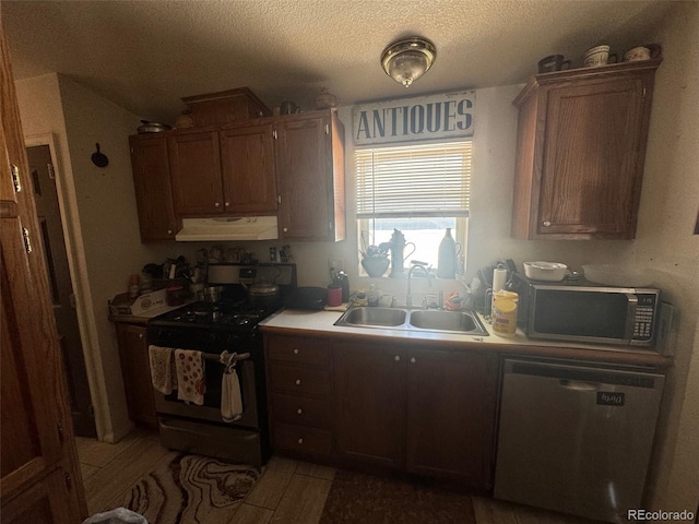 kitchen with a textured ceiling, sink, and appliances with stainless steel finishes