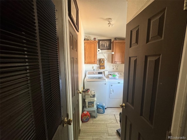 washroom with light tile patterned floors, independent washer and dryer, and cabinets