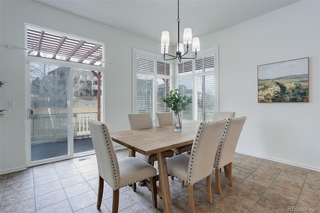 dining space with a chandelier, a healthy amount of sunlight, and baseboards