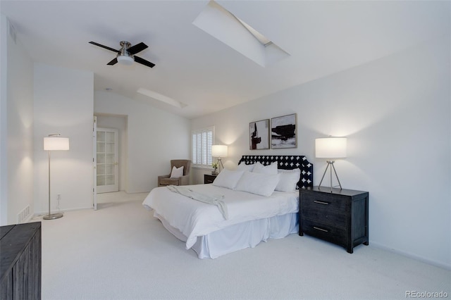 carpeted bedroom featuring ceiling fan, lofted ceiling with skylight, and baseboards