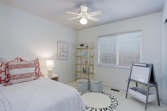 bedroom with baseboards, visible vents, a ceiling fan, and light colored carpet