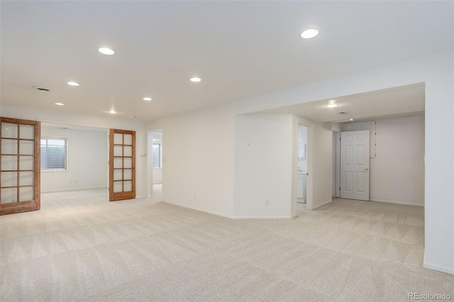 empty room with light carpet, baseboards, and recessed lighting