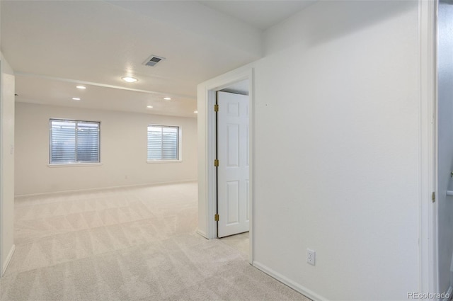 spare room featuring baseboards, recessed lighting, visible vents, and light colored carpet